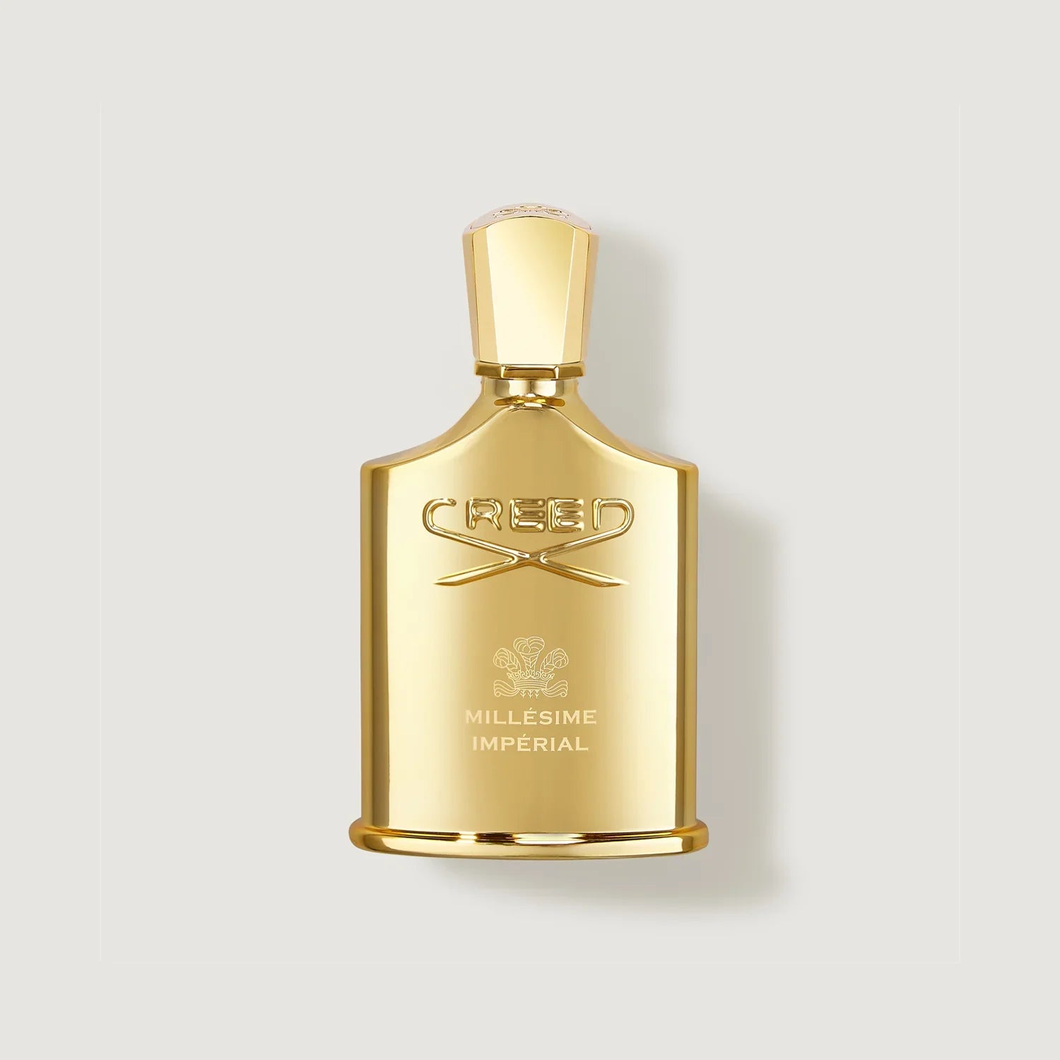 Gold Creed perfume bottle on a light gray background