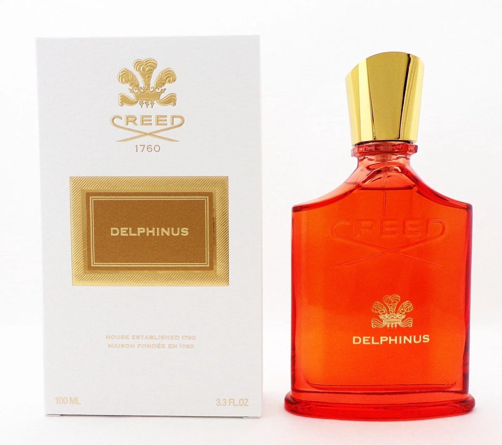 Red Creed Delphinus perfume bottle with gold cap and packaging on a white background